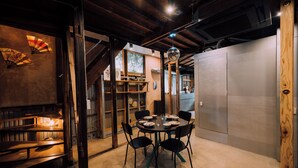 A dining area with a round table, black chairs, and a chandelier. - Ivy Place Harajuku Urban Steel Teahouse (Tokyo)