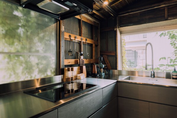 Une cuisine moderne dotée d’un plan de travail en acier inoxydable, de meubles en bois et d’une cuisinière encastrée.