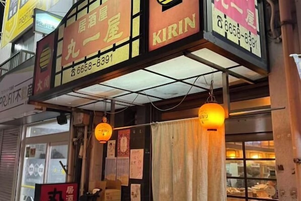 A restaurant with signage in a foreign language, a contact number, and hanging lanterns. - GARDEN HOUSE (Osaka)