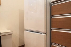 Un refrigerador blanco y un armario de madera en una cocina.