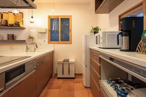 Eine Küche mit Mikrowelle, Kaffeemaschine und Spüle.