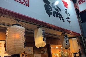 A restaurant with traditional Japanese lanterns hanging above the entrance. - GARDEN HOUSE (Osaka)