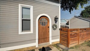 Une maison avec une porte d’entrée en bois, une fenêtre et une boîte aux lettres.