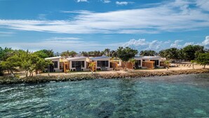 A beachfront property with modern villas, clear blue water, and palm trees. - Bullock Island, Belize (Placencia)