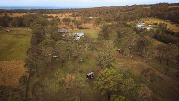 A rural landscape with scattered buildings, a large open field, and dense forest areas.