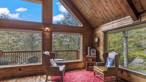 A wooden cabin with large windows, a red rug, and two leather chairs. - Mountain cabin w/ deck & lake access (Terra Alta)