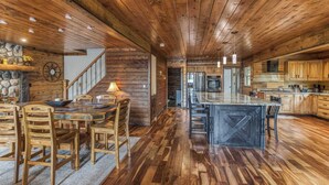A spacious kitchen with wooden floors, a large island, and modern appliances. - Mountain cabin w/ deck & lake access (Terra Alta)