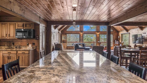 A spacious kitchen with a large granite island, wooden cabinets, and a built-in microwave. - Mountain cabin w/ deck & lake access (Terra Alta)