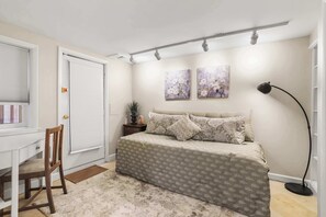Ein Schlafzimmer mit Bett, Schreibtisch und Stuhl.