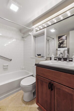 Ein modernes Badezimmer mit Badewanne, Toilette, Waschtisch mit Spiegel und Dusche.