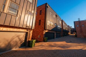 Une rue moderne en milieu urbain, bordée d’immeubles dotés de grandes fenêtres et de portes de garage.