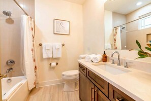 Un baño con bañera, inodoro, lavabo y zona de ducha.