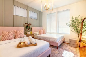 A hotel room with two beds, a large window, a chandelier, and a plant. - Rooftop skyline views near Broadway | sleeps 12 in Nashville (Nashville)