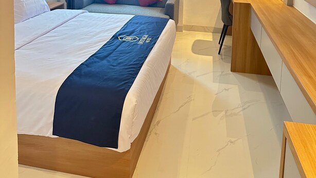 A modern hotel room with a bed, a desk, and a TV. - Hotel Dotaga (Malinau)