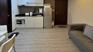 Un apartamento moderno con kitchenette, un sofá y zona de comedor.