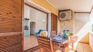 Una mesa de madera con sillas en un balcón que ofrece vistas del interior.