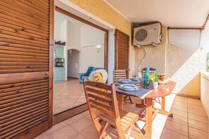 A wooden table with chairs on a balcony with a view of the interior. - Domus De Pedra Pertunta (Castelsardo)