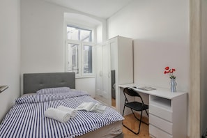 Ein Schlafzimmer mit Bett, Schreibtisch, Stuhl und Kleiderschrank.
