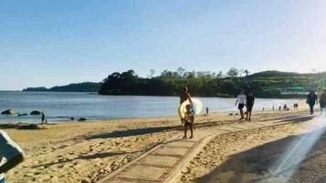A sandy beach with a paved walkway.