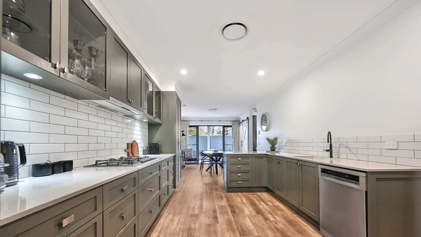 A modern kitchen with grey cabinets, white subway tiles, and a wooden floor. - Woodward Links • Walk to CBD • Near Duntryleague (Orange)