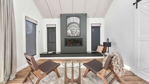 A modern living room with a fireplace, two chairs, a glass coffee table, and a sofa. - Woodward Links • Walk to CBD • Near Duntryleague (Orange)