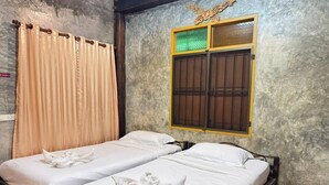 A room with two beds, beige curtains, a window with a decorative frame, and a textured wall. - Collection O Baan Elephant Home (Chiang Mai)
