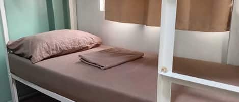 A bunk bed with a single bed on top and a lower bunk.