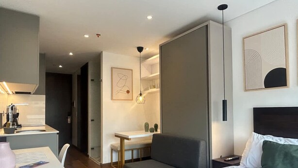 A modern hotel room with a bed, a desk, a chair, and a small table. - NOK Centric Loft in Parque 93 (Bogotá)