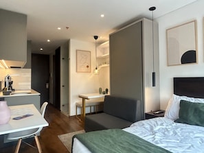 Una moderna camera d'albergo con un letto, una scrivania, una sedia e un tavolino.