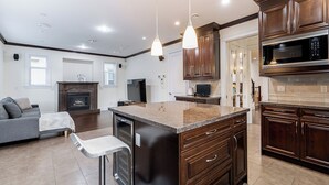 A modern kitchen with dark wood cabinets, a granite countertop, and stainless steel appliances.