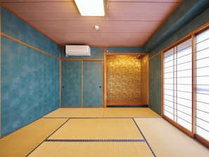 A traditional Japanese room with tatami flooring, sliding doors, and a ceiling-mounted air conditioner.
