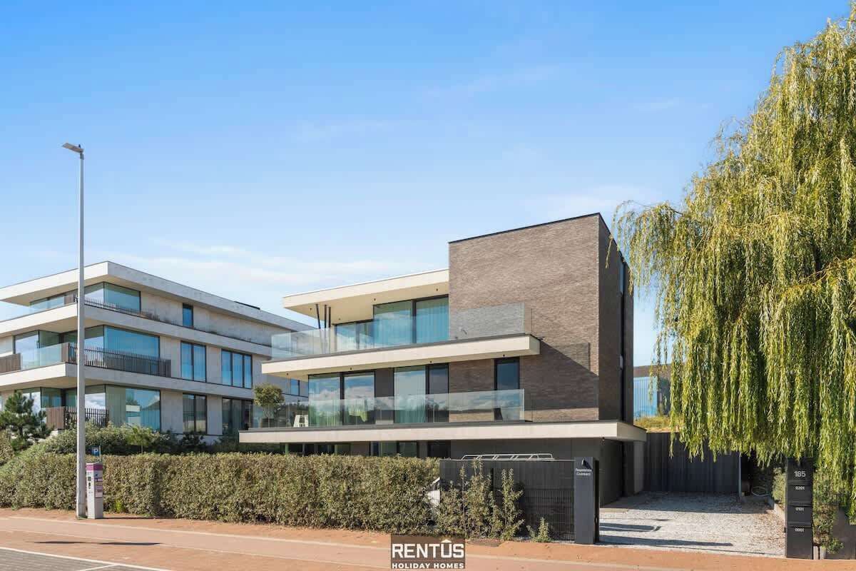 A modern multi-story building with large windows and a flat roof.
