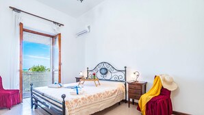 A bedroom with a bed, bedside table, and a view of the outdoors. - Bilo Asfodelo Alghero Centro (Alghero)