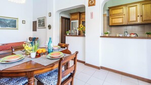 A dining area with a wooden table set for four, surrounded by chairs with patterned cushions. - Bilo Asfodelo Alghero Centro (Alghero)