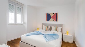 Una camera da letto moderna con un letto, comodini e una finestra.