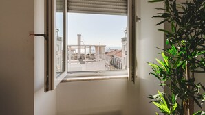 Una finestra con vista su edifici e una pianta all'interno.