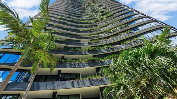 A modern high-rise building with multiple balconies, some with greenery. - Fortitude Valley 1BRM with Skyline Views (Fortitude Valley)