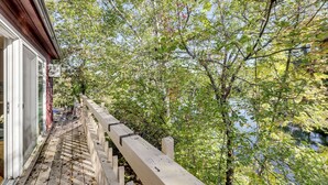 A wooden deck with a railing overlooking a body of water, surrounded by trees. - All-Season Lakefront Escape 8 Mi to Mount Sunapee (Bradford)