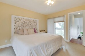 A bedroom with a large bed, a decorative headboard, a desk, and a window with blinds. - Pets Welcome: Beachfront Family Retreat in Norfolk (Norfolk)