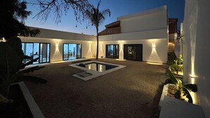 A modern house with a swimming pool, large windows, and outdoor lighting. - u paradisu villas (Jambiani)