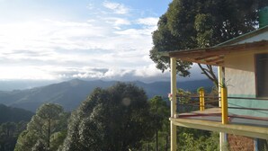 Un edificio con balcón que da a un paisaje montañoso.