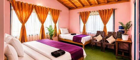 Une chambre d’hôtel avec deux lits, un bureau, des chaises et une moquette verte.