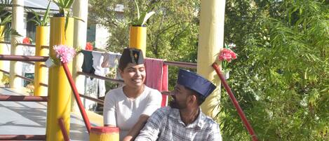 A man and a woman sitting on a bench with yellow pillars and red accents.