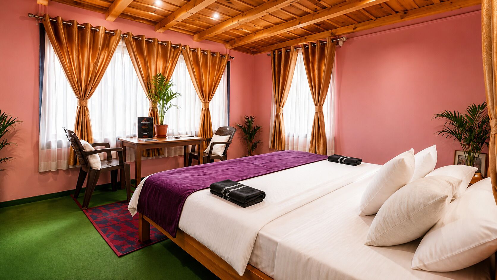 Ein Hotelzimmer mit einem Bett, einem Schreibtisch, einem Sessel und einem kleinen Tisch.