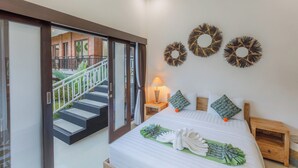 Une chambre d’hôtel avec un lit, une table de chevet, une lampe et une vue sur le balcon extérieur.
