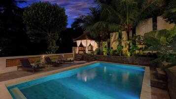 Alberca al aire libre y camastros
