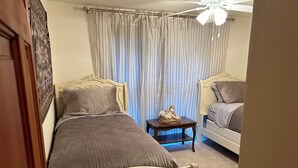 A bedroom with two beds, a small table, and a ceiling fan. - 2-bedroom home in Sedona on the creek (Sedona)