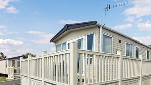 A mobile home with a balcony, a satellite dish, and a clear sky. - Birch 2 Bedroom Pet Friendly (Clynderwen)