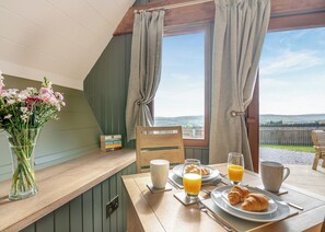 A breakfast table with croissants, orange juice, and a vase of flowers. - 1 bedroom accommodation in Ripponden (Ripponden)