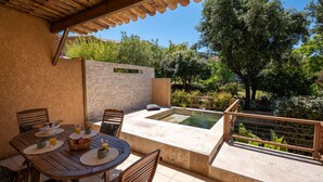 An outdoor patio with a table and chairs, a stone wall, and a small pool. - residence Guddelmoni (Propriano)